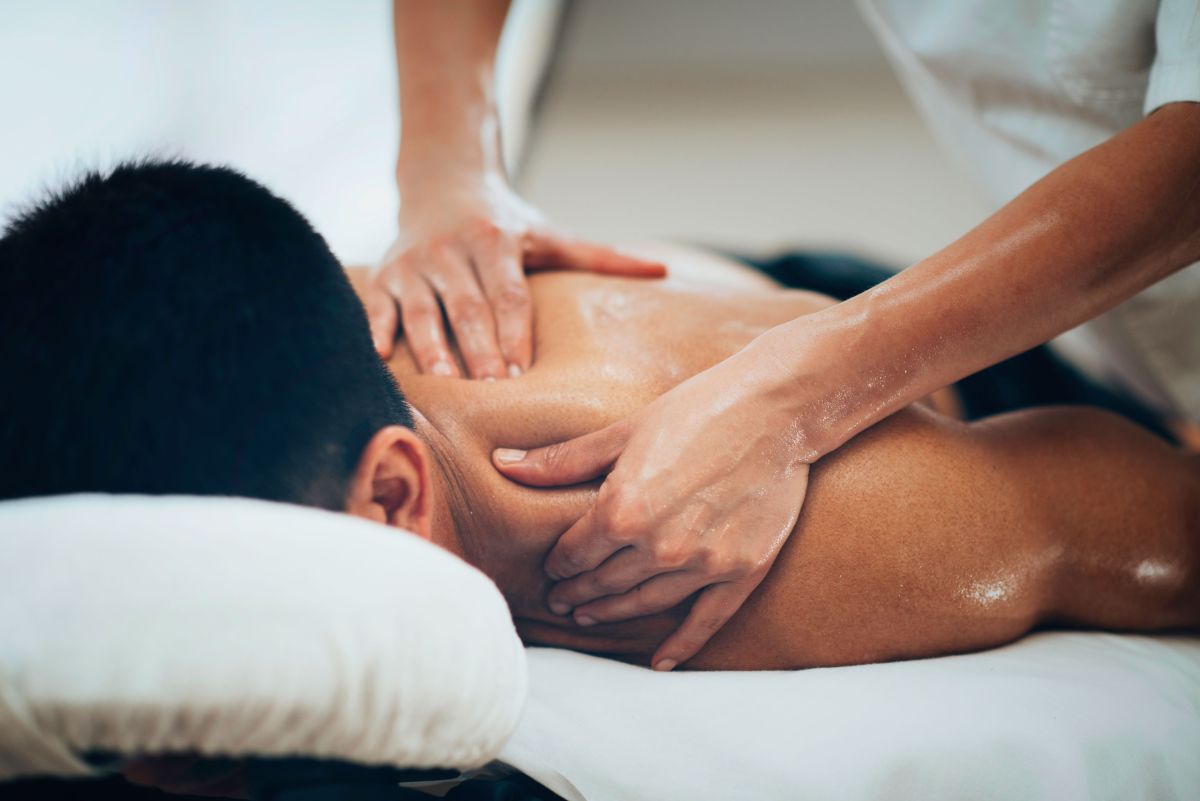 Man receiving massage to neck and shoulder