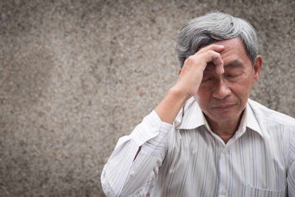 an elderly man experiencing a headache 