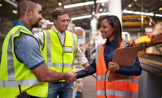 A supervisor shaking hands with a worker in a distribution center.
